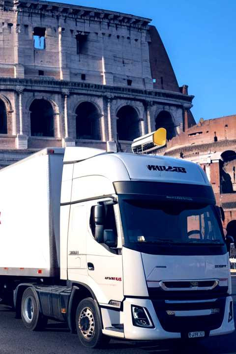 navi_international_Default_A_truck_with_a_trailer_in_front_of_the_Colosseum_in_Ro_0.jpg